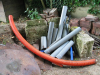 Photo d'une zone de stockage de chantier avec gaine rouge, chutes de tubes PVC, tuiles et blocs de béton mélangés 500 utilisé pour un crapauduc